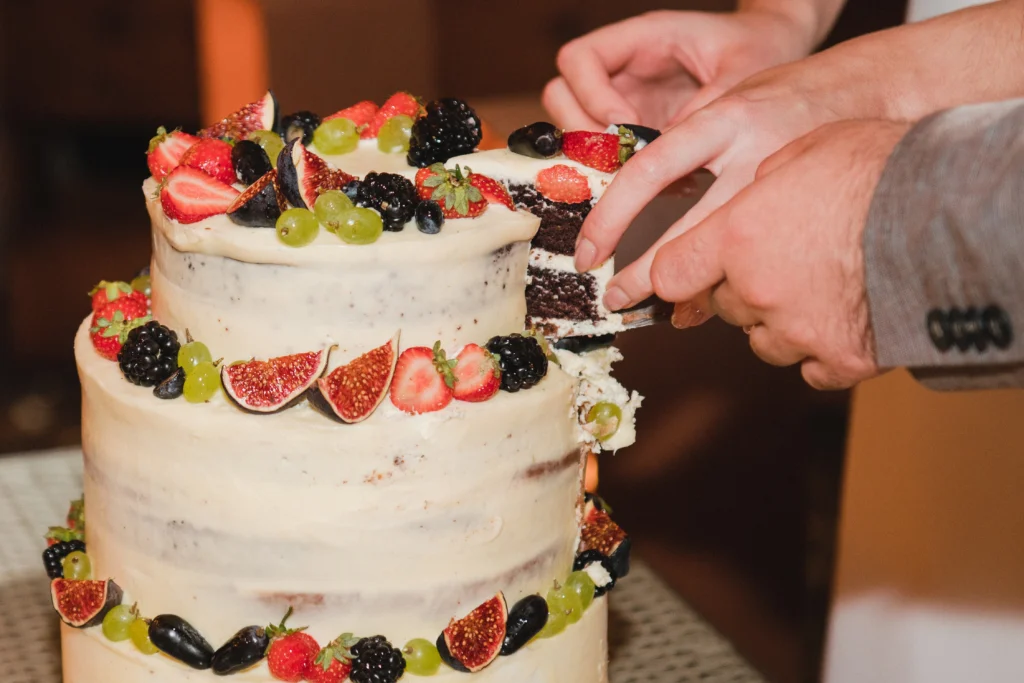 Elegant wedding cake decorated with flowers and intricate icing details.