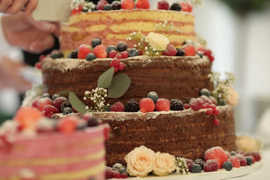 Beautiful wedding cake with multiple tiers, adorned with flowers and intricate decorative details.